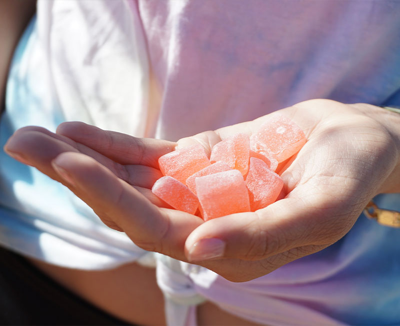 Hand holding pink gummies