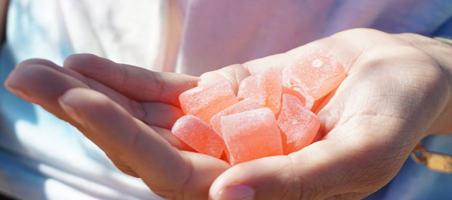 Hand holding pink gummies